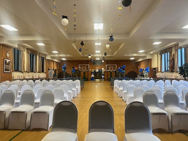 Decorated gymnasium set up for graduation ceremony with white chairs
