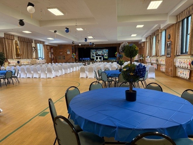 Graduation reception hall with blue tablecloths and floral centerpieces