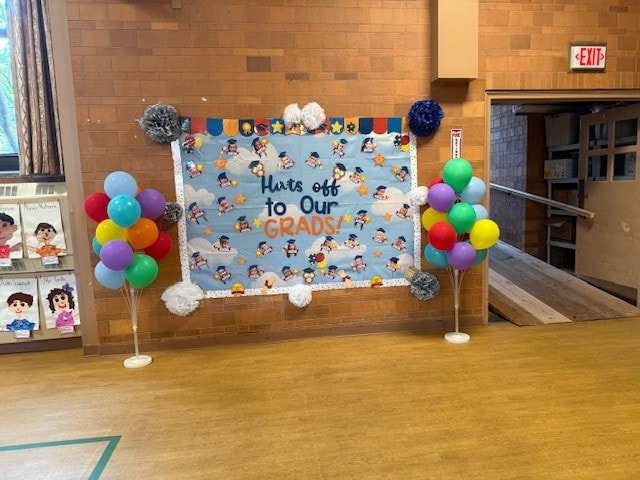 Hats Off to Our Grads banner with colorful balloon trees