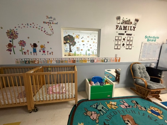 Wantagh infant room with cribs and family wall decor